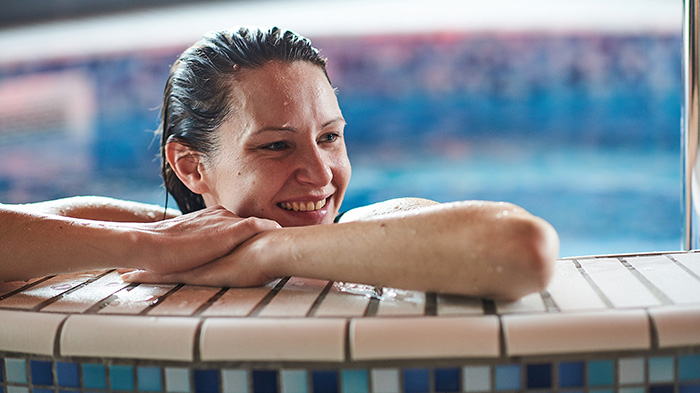 Kvinna som hänger på kanten av en bubbelpool