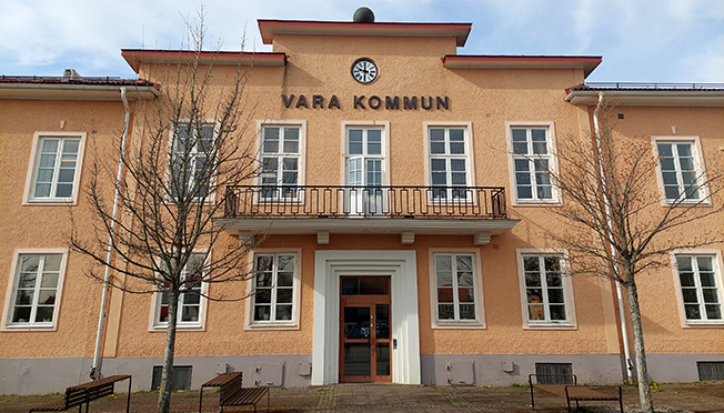 Stort gult hus med skylt Vara kommun.