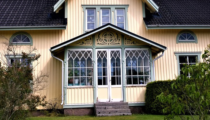 Gult trähus med snickarglädje.