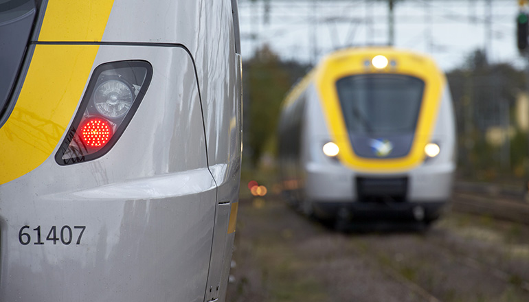 Närbild på framsida av tåg, ett annat tåg i bakgrunden.